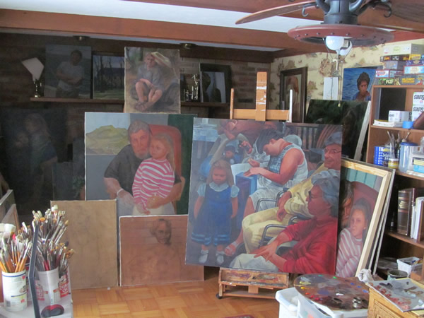 "The Gift" (large painting on the right) and several smaller paintings.